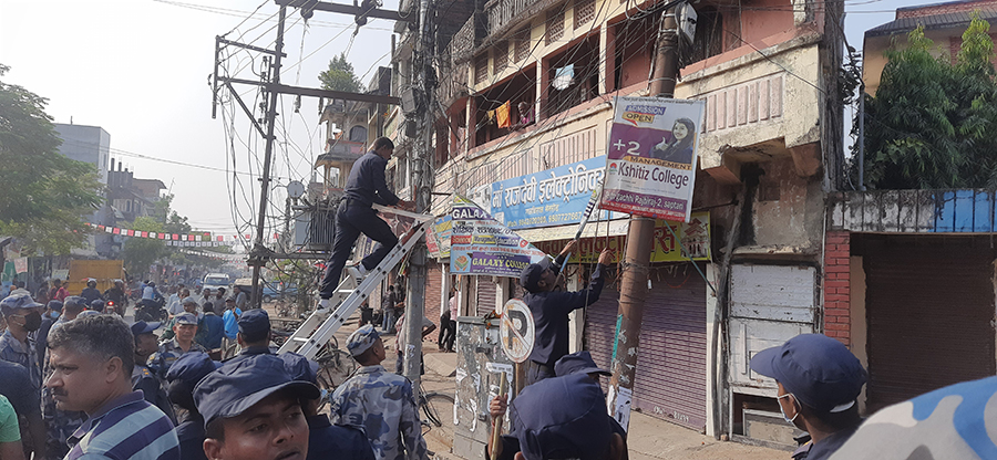 प्रहरीले सप्तरीमा निर्वाचन आचारसंहिता विपरीतका प्रचार सामग्री हटाउँदै